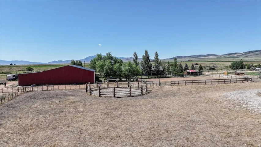 Expansive property featuring a red barn, round pen, and a large arena area