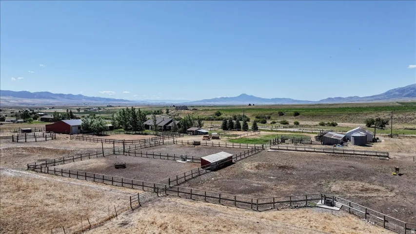 Expansive agricultural property featuring multiple fenced paddocks, a red barn with a metal roof, and additional outbuildings