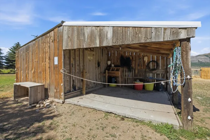 Rustic wooden outbuilding with a corrugated metal roof and a concrete floor