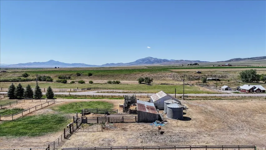 Expansive rural property featuring multiple outbuildings, agricultural silos, and fenced enclosures