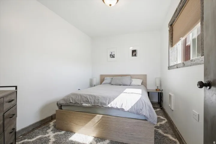 Neutral white walls featuring a window with a wood-frame trim