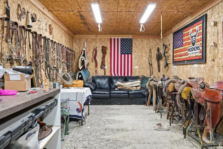 Utility space featuring oriented strand board walls and ceiling, concrete flooring, and fluorescent overhead lighting
