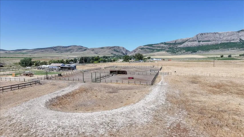 Expansive property featuring a large fenced paddock, additional fenced areas, and a visible outbuilding