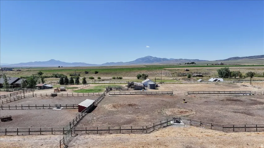 Expansive fenced paddocks with multiple outbuildings, including a red shed and several barns