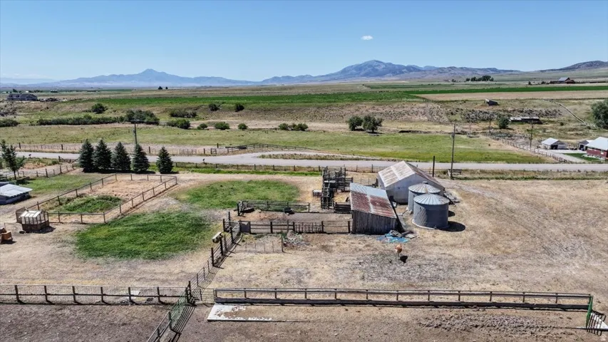 Agricultural property featuring multiple outbuildings, fenced enclosures, and a silo system