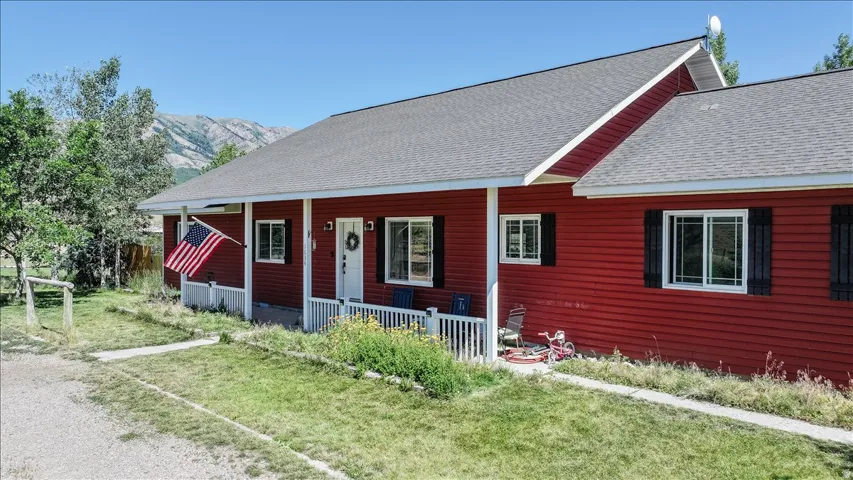 Red exterior siding with a covered porch and white columns