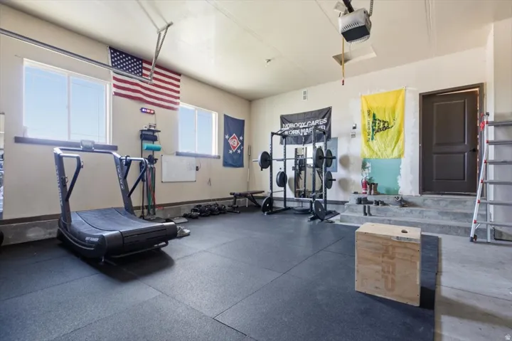 Garage space featuring rubber flooring, multiple windows, an interior access door, and painted walls