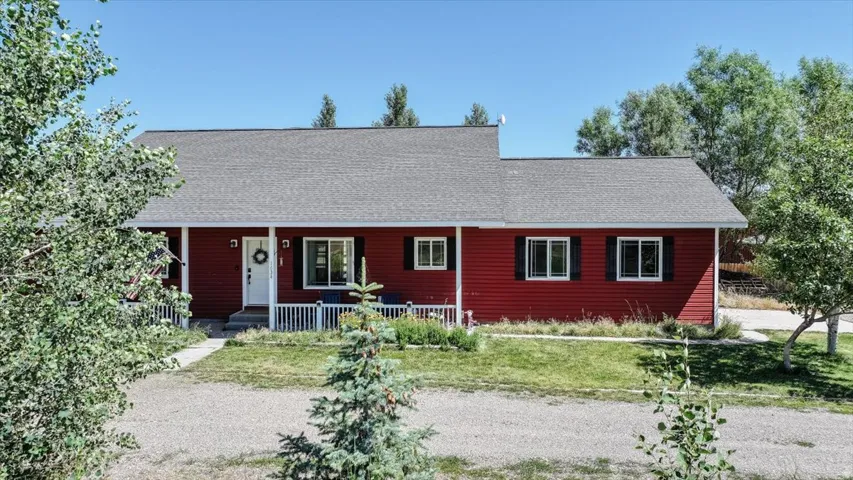 Red siding exterior with a covered front porch featuring white railings