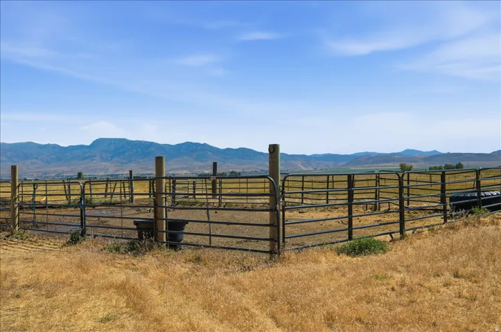 Enclosed paddock area featuring metal fencing, wood posts, and a metal gate