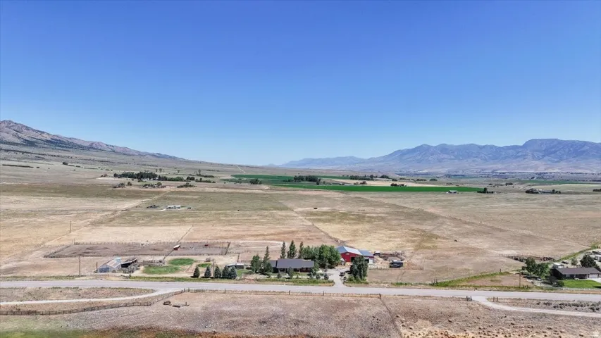 Expansive rural property featuring a single-story residence, multiple outbuildings, and extensive open land