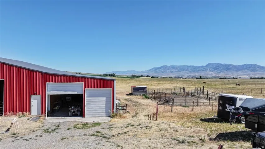 Red metal-sided barn with multiple bay doors and an entry door