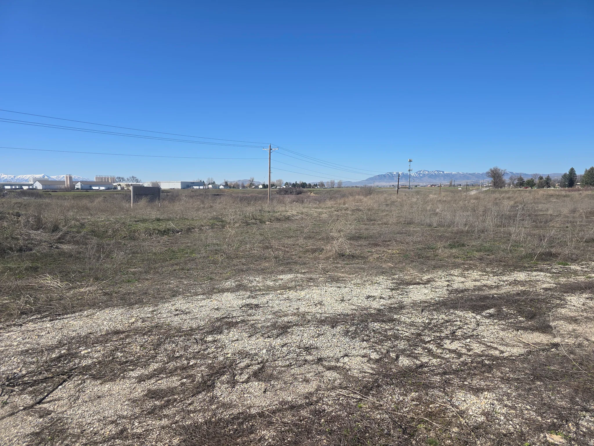 Expansive open land featuring natural vegetation and distant mountain scenery