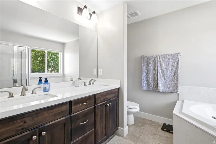 Dual sink vanity with dark wood-finish cabinetry and light-toned countertops