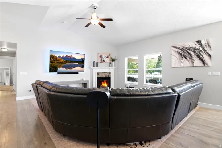 Living area featuring a fireplace with stone surround, a white mantle, and a wall-mounted television