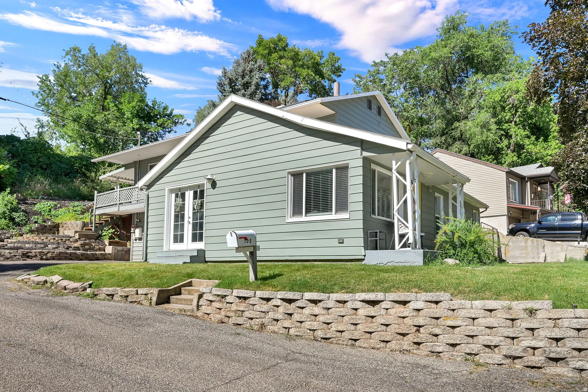 Light green siding exterior with white trim accents and a covered front porch