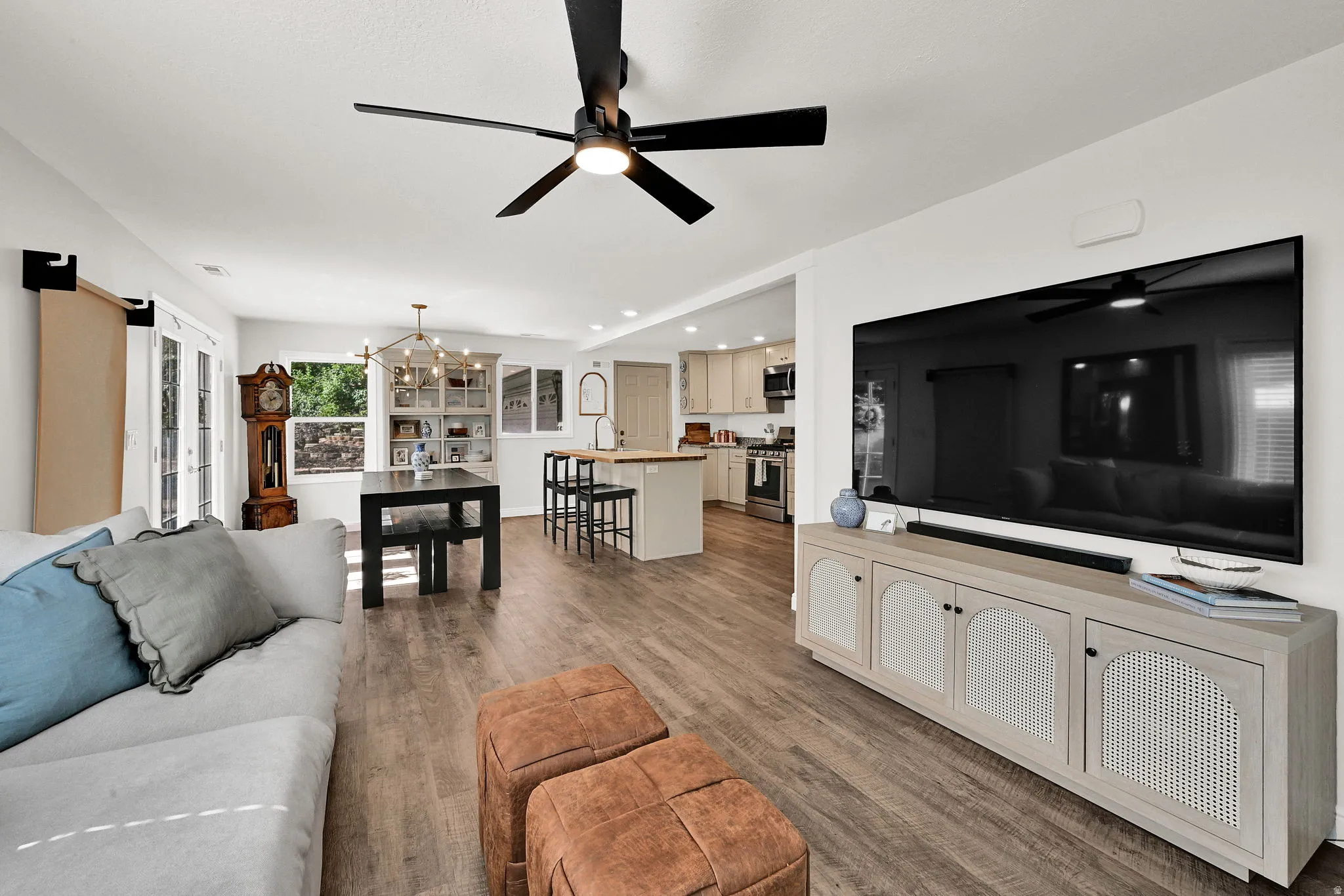 Open-concept living area featuring wood-finish flooring and a contemporary ceiling fan with integrated lighting