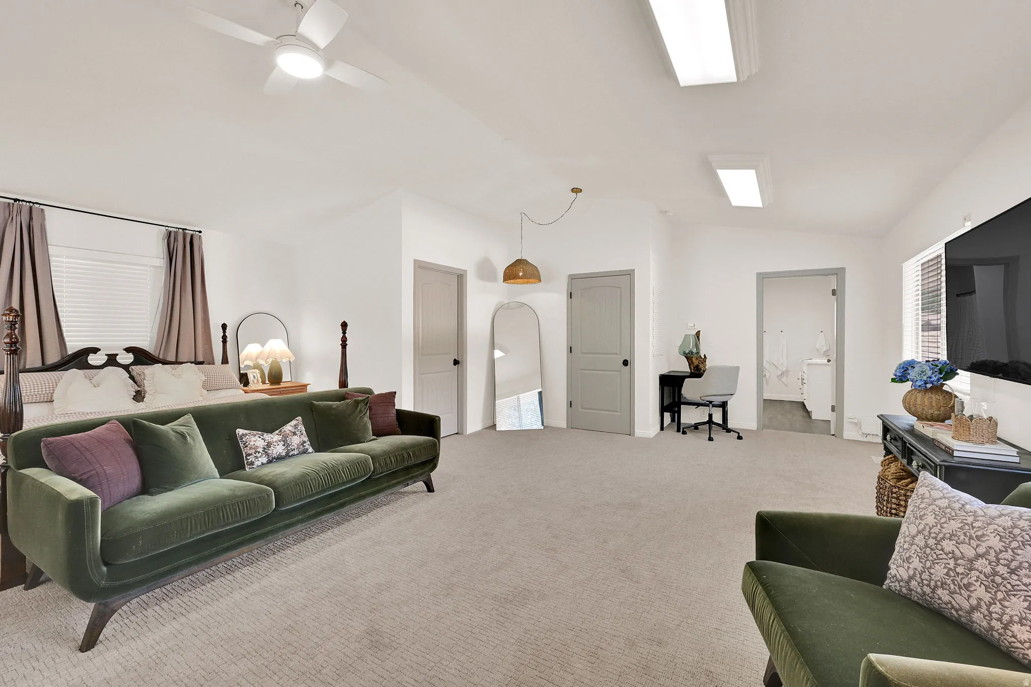 Spacious owners suite featuring vaulted ceilings, recessed lighting, and multiple paneled doors
