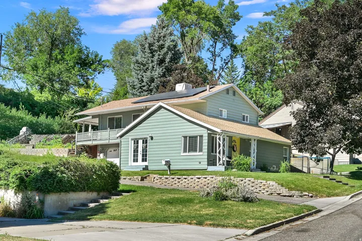 Two-story property featuring light green siding and a covered front porch