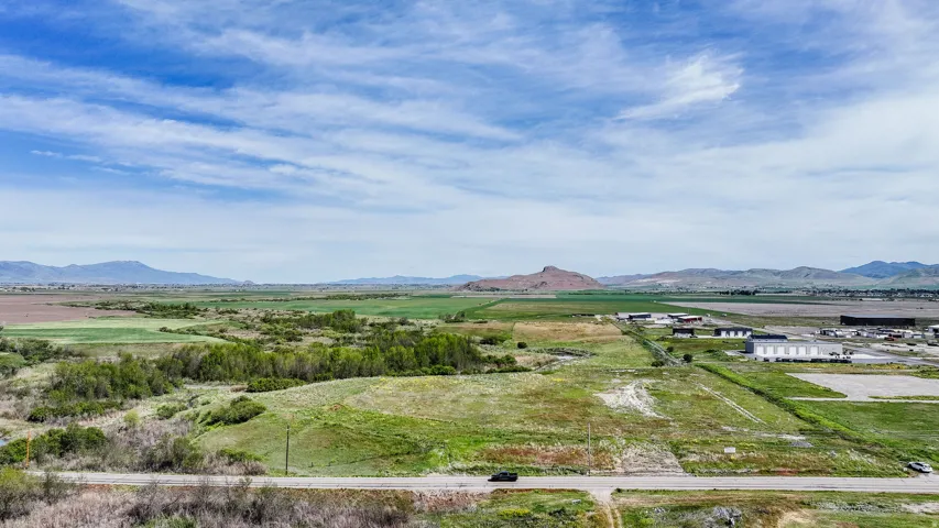 Expansive rural landscape featuring distant mountains and cultivated fields