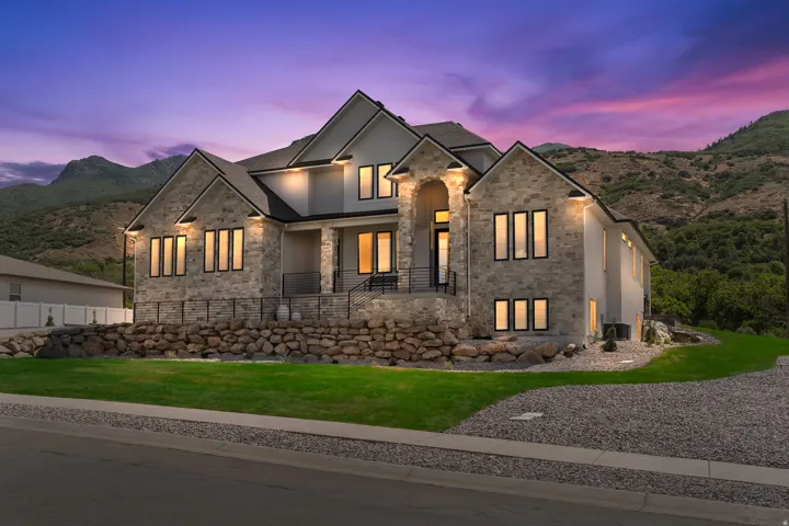 Stone and stucco exterior with multiple gables and black-trimmed windows