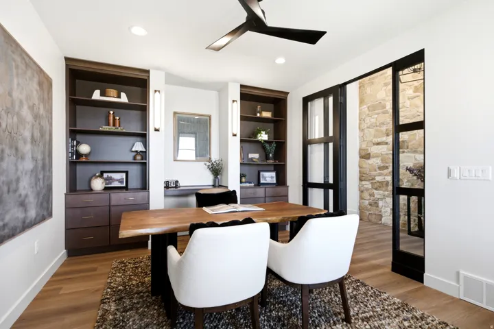 Contemporary interior featuring wood-finish flooring, built-in shelving with integrated cabinetry, and a black ceiling fan