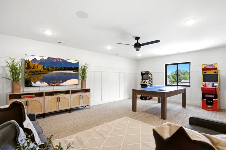 Spacious recreation room featuring wainscoting, recessed lighting, and a neutral carpet