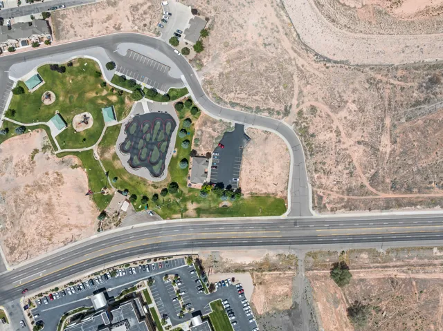 Community park featuring green spaces, shaded play structures, and paved pathways