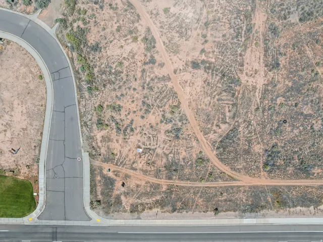 Aerial overview showcasing a developed roadway with a cul-de-sac turn, bordered by a concrete sidewalk
