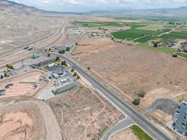 Expansive undeveloped land parcels with varied topography, bordered by roadways and developed commercial properties