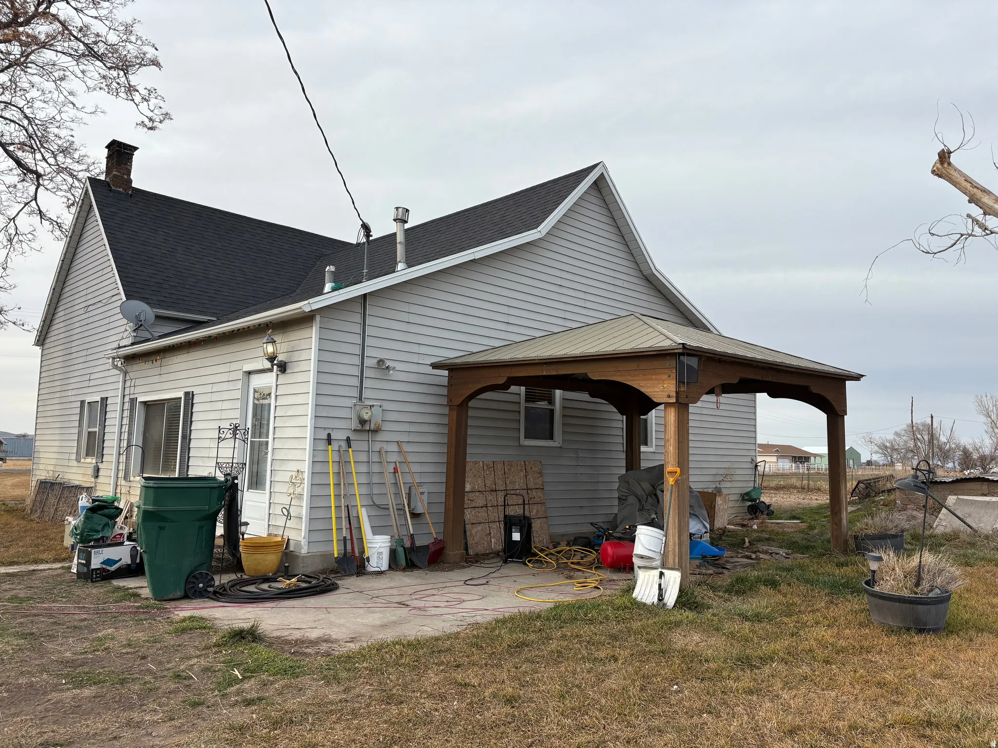 Exterior siding with an attached wooden gazebo featuring a metal roof