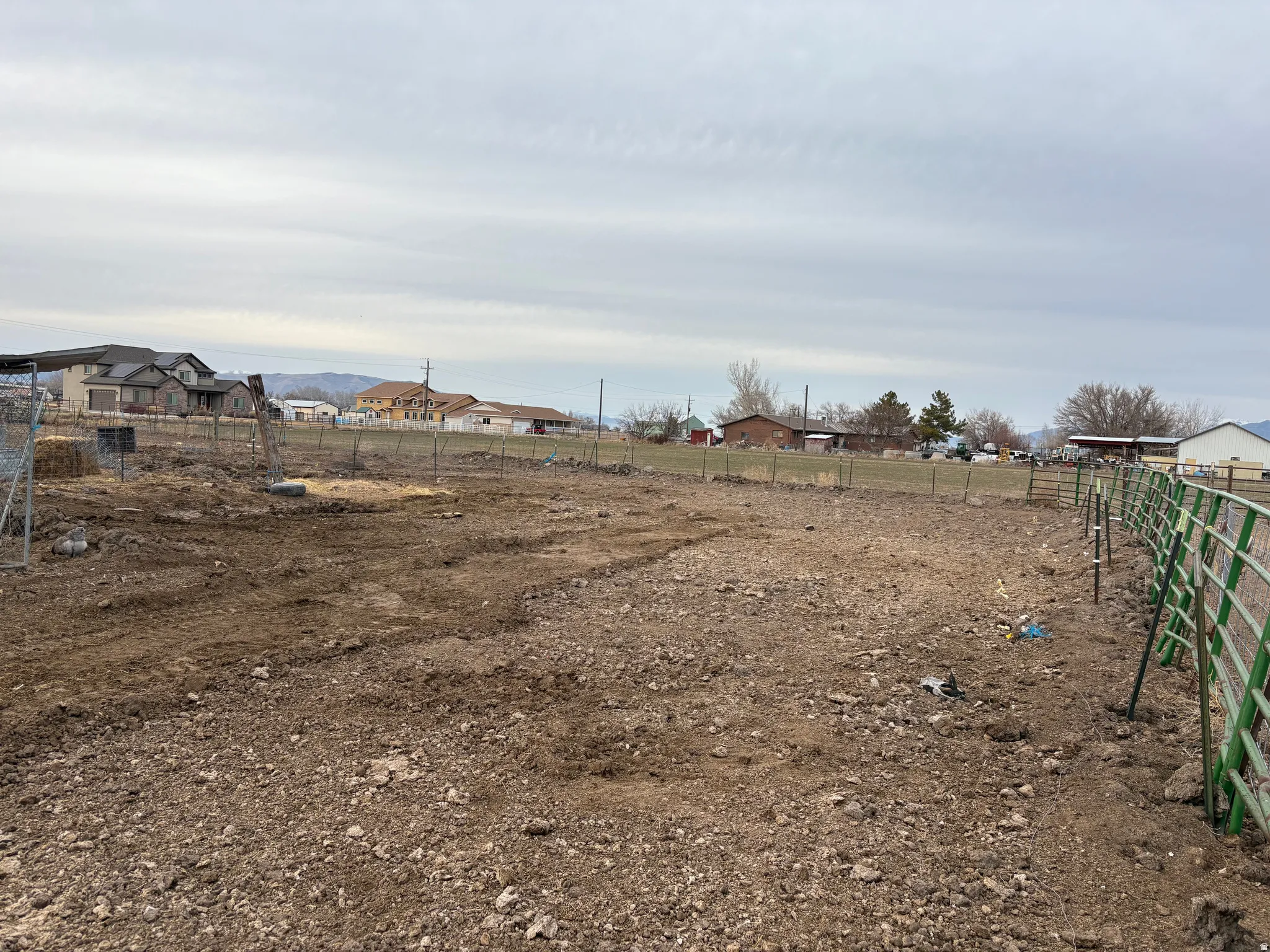 Expansive open lot featuring a perimeter fence and varied ground cover