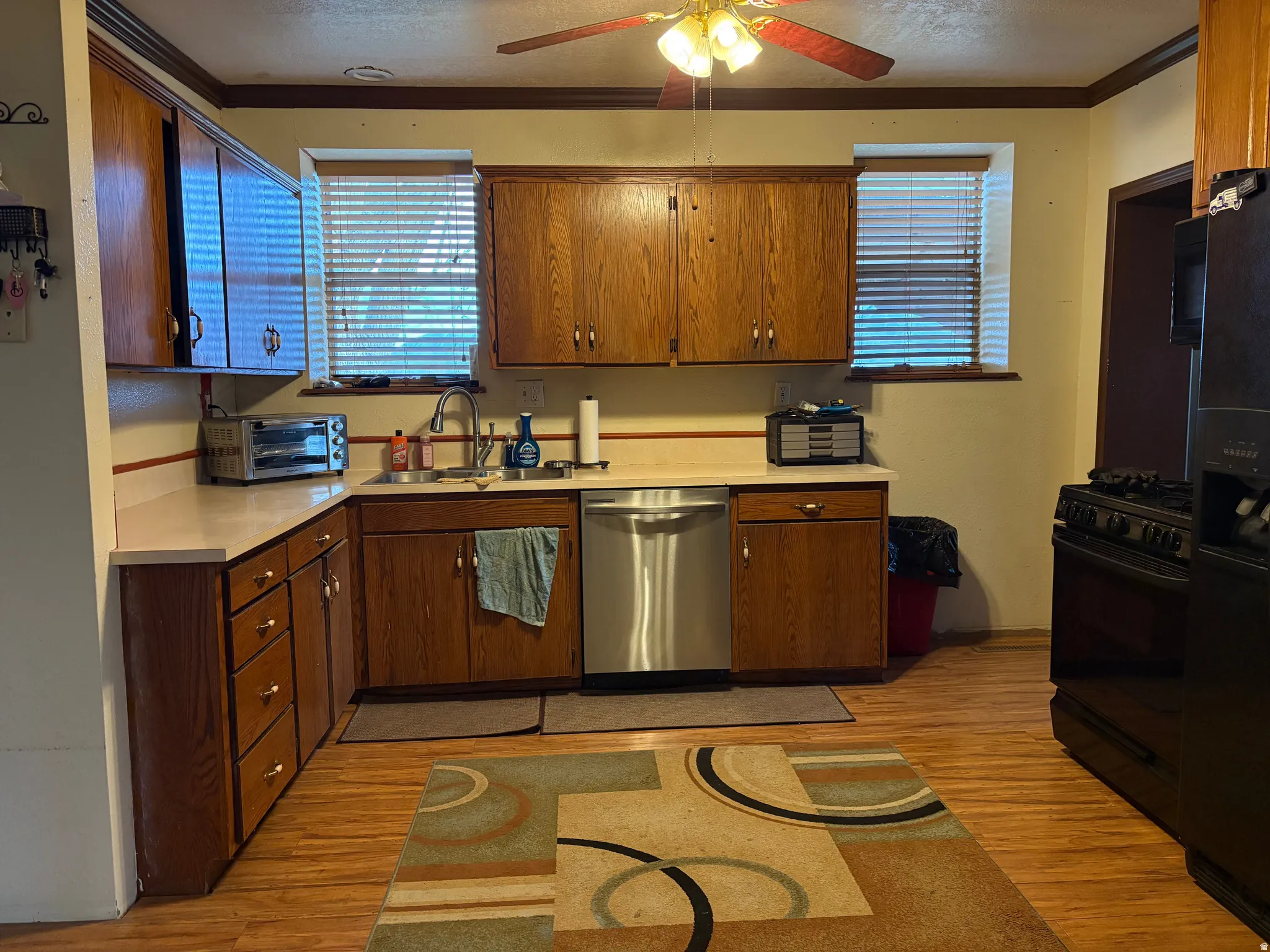 Kitchen featuring wood-finish cabinetry, light countertops, and wood-finish flooring
