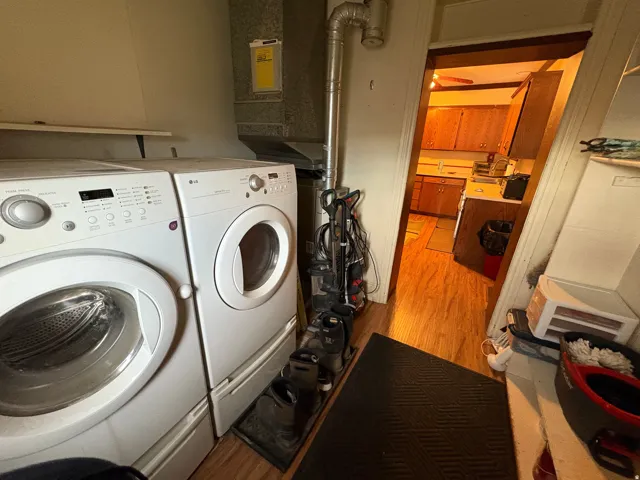 Laundry area with a permanent wood shelf and utility hookups