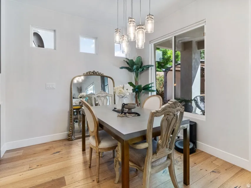 Dining area featuring wood-finish flooring, a multi-pendant light fixture, and a large sliding glass door
