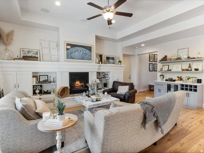 Spacious living area featuring a fireplace with a detailed mantelpiece, built-in shelving, and recessed lighting