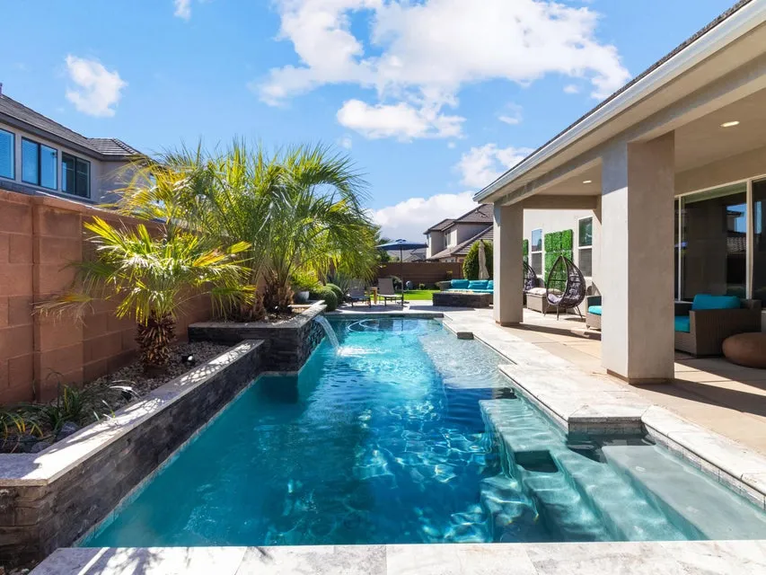 Rectangular swimming pool featuring integrated steps and a waterfall feature