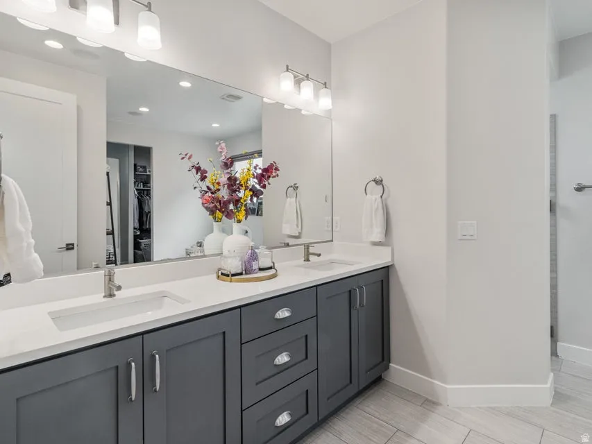 Dual vanity with integrated rectangular sinks, white countertops, and gray shaker-style cabinetry