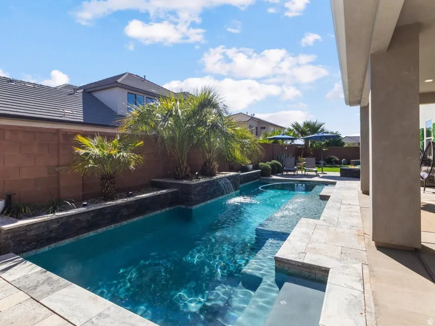 Private backyard featuring a swimming pool with integrated spa and water features