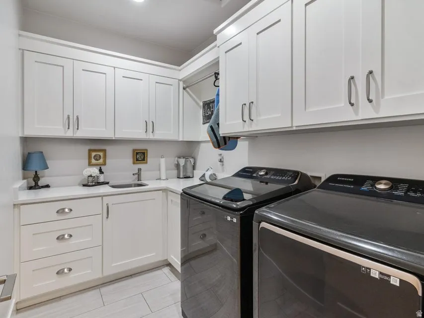 Laundry room featuring white shaker cabinetry, an undermount sink, solid surface countertops, and tile flooring