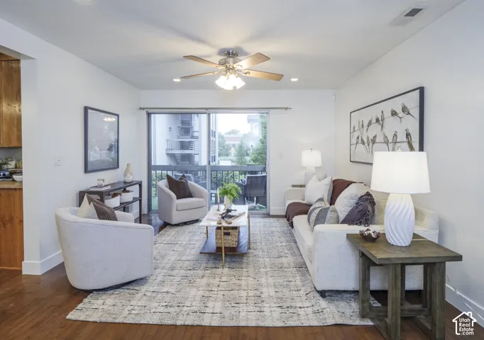 Living area featuring wood-finish flooring, a ceiling fan with integrated lighting, recessed lighting, and a sliding glass door