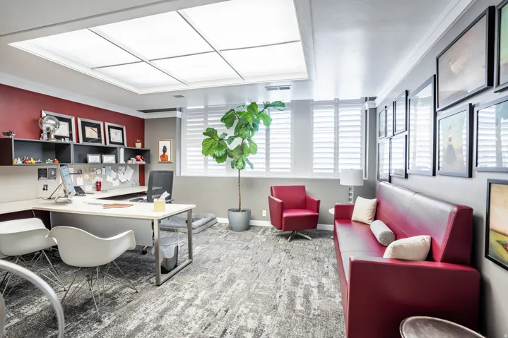 Spacious room with a large overhead light panel and grey-patterned carpeting