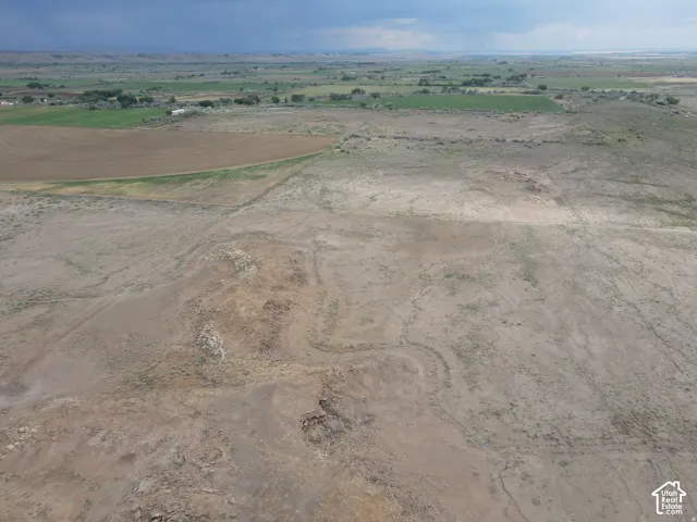 Expansive undeveloped land featuring varied terrain and distant cultivated fields