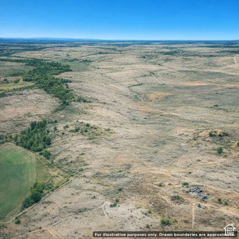 Expansive open landscape with varied terrain, featuring natural vegetation and distant tree lines