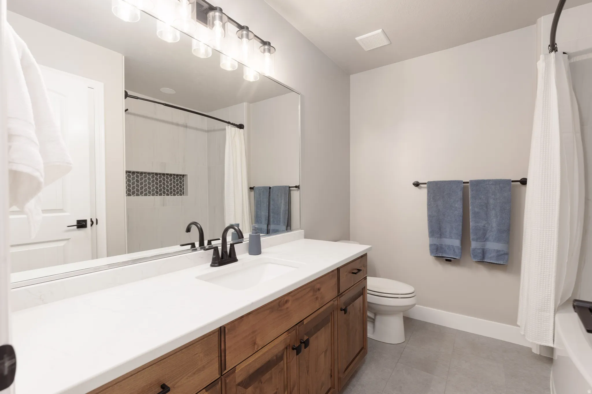 Extra long vanity with a white countertop and wood-finish cabinetry
