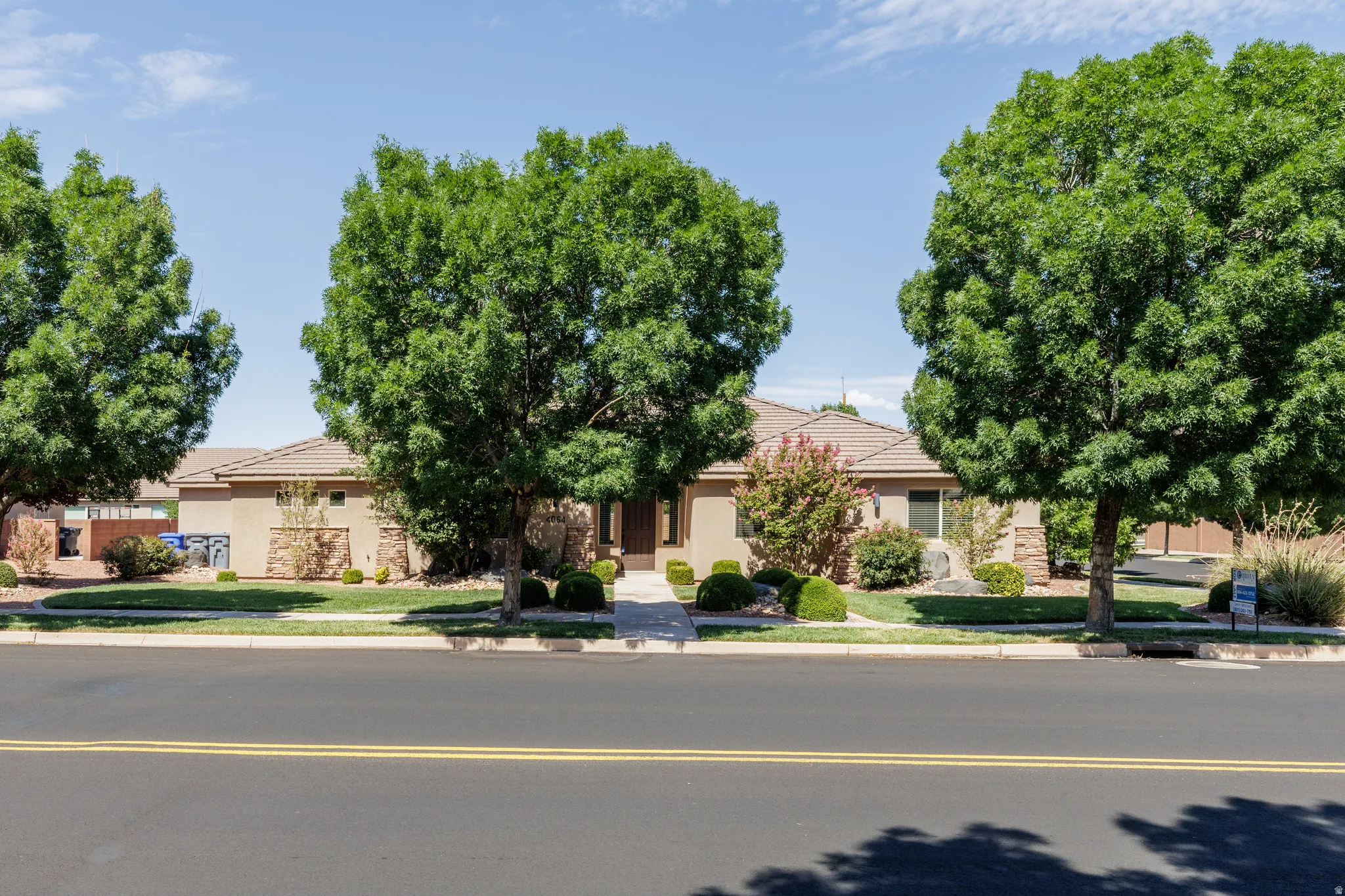Front houseSingle-story stucco exterior with a tile roof and integrated stone accents