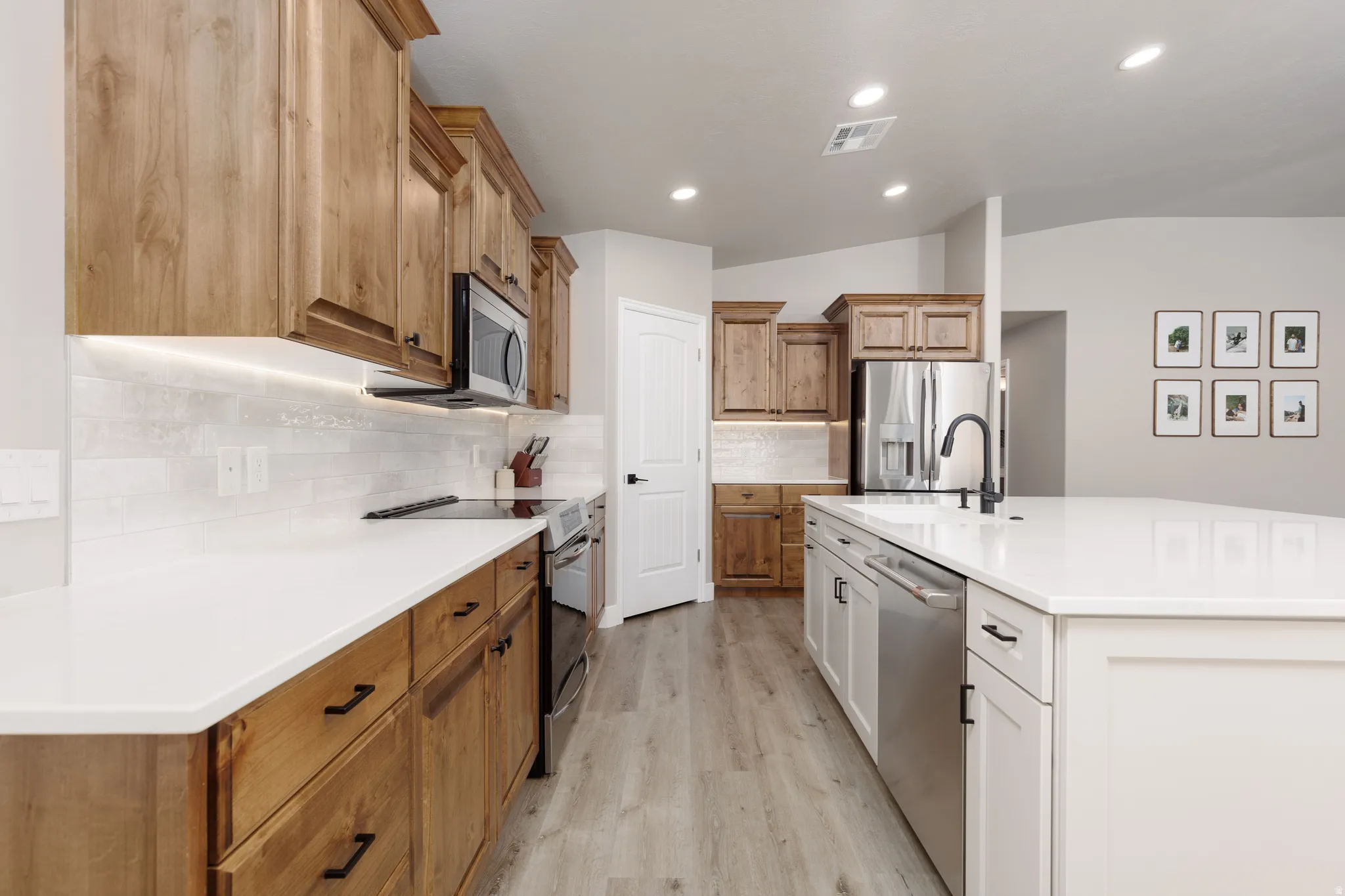 Kitchen featuring a large central island with white cabinetry and a light-toned countertop