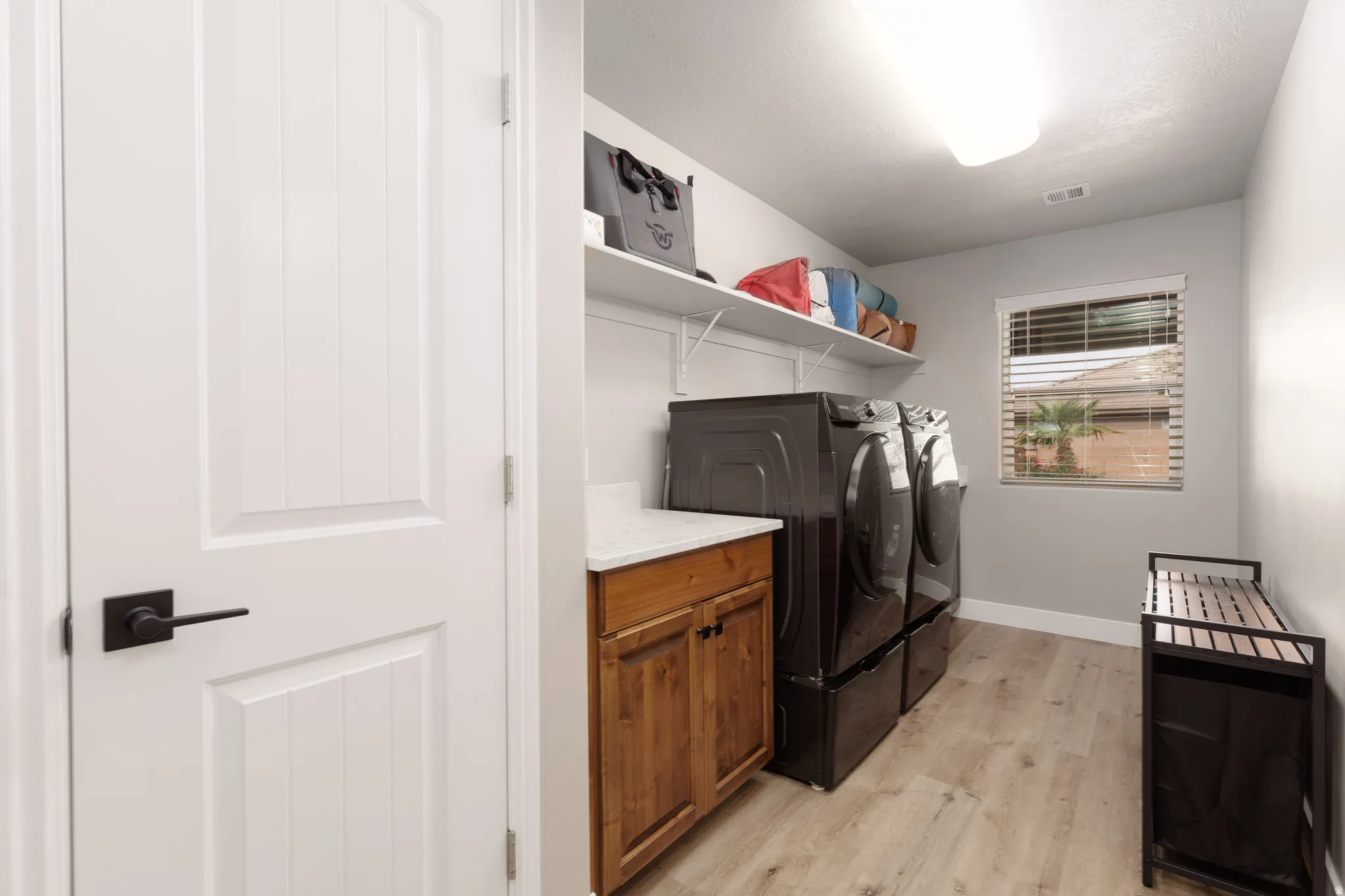 Large laundry room with closet, shelving and cabinet storage