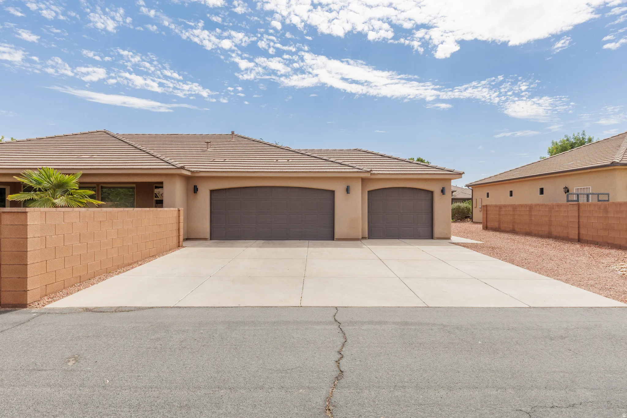 Single-story residence featuring a tan stucco exterior and a multi-car concrete driveway and RV parking