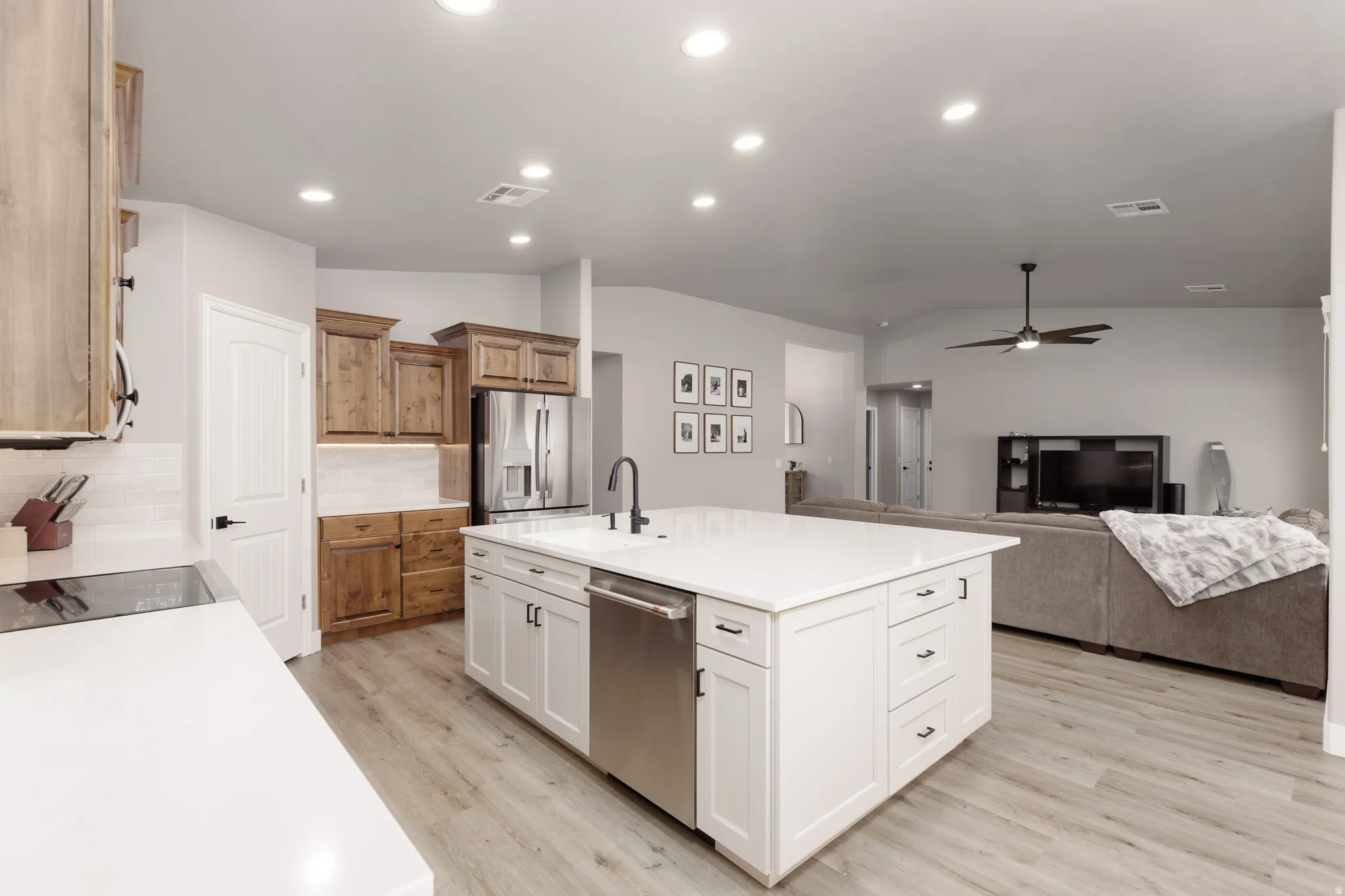 Modern kitchen featuring a large central island with white cabinetry and a built-in stainless steel dishwasher