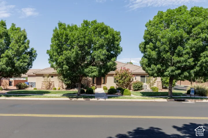 Front houseSingle-story stucco exterior with a tile roof and integrated stone accents